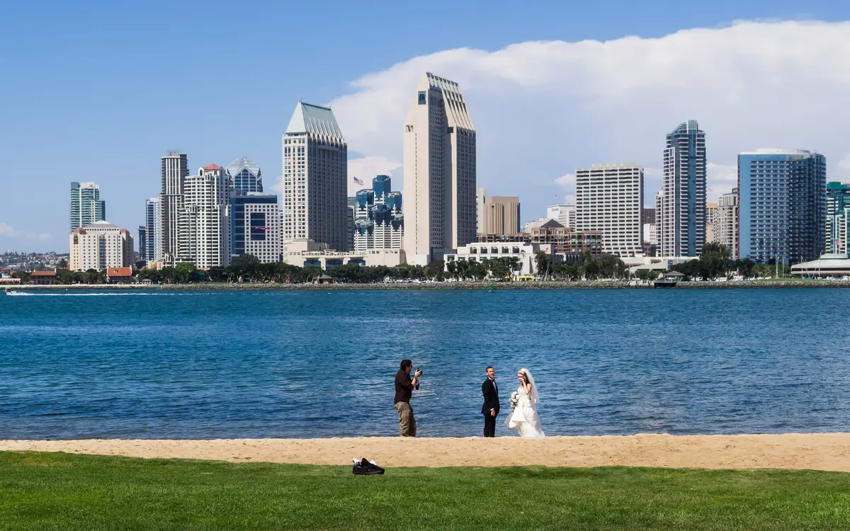 Web design in San Diego: Bridal pair during a photoshooting in front of the skyline of San Diego